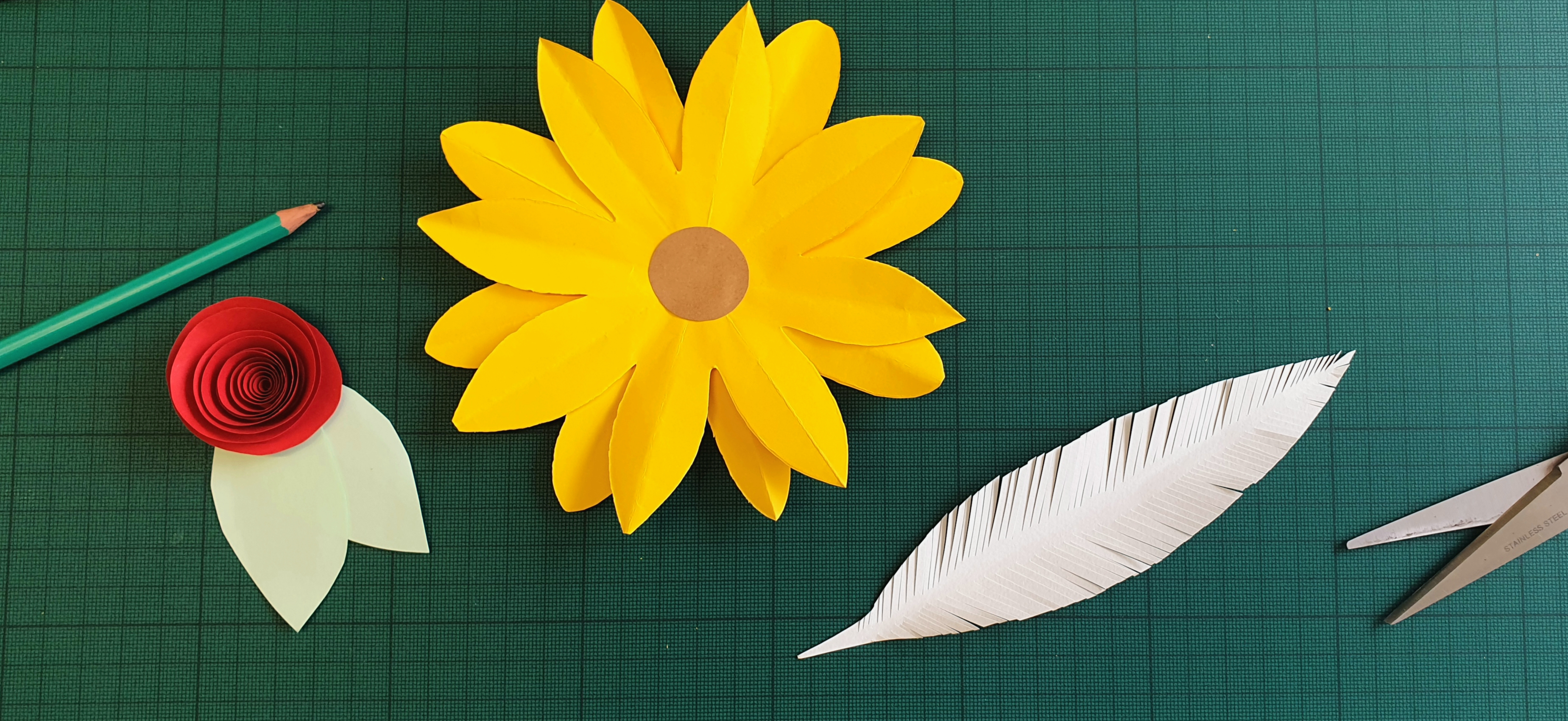 Images of paper crafted items: a sunflower, rolled rose and feather